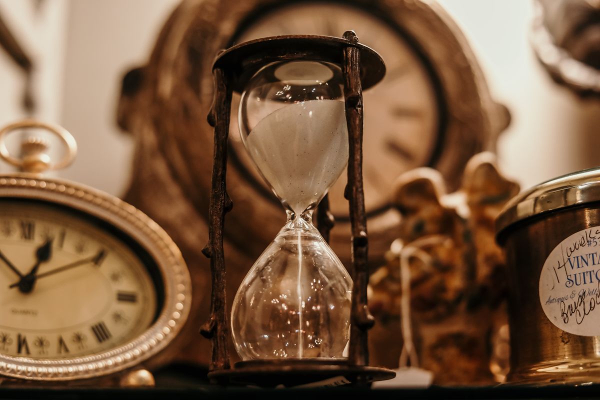 A warm sand-filled hourglass on a sunlit surface — a quiet image for thinking about how long therapy takes